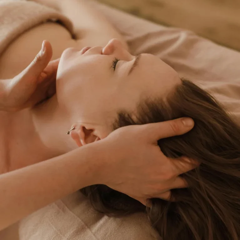 Chiropractor's hands gently massaging a patient's neck and head.